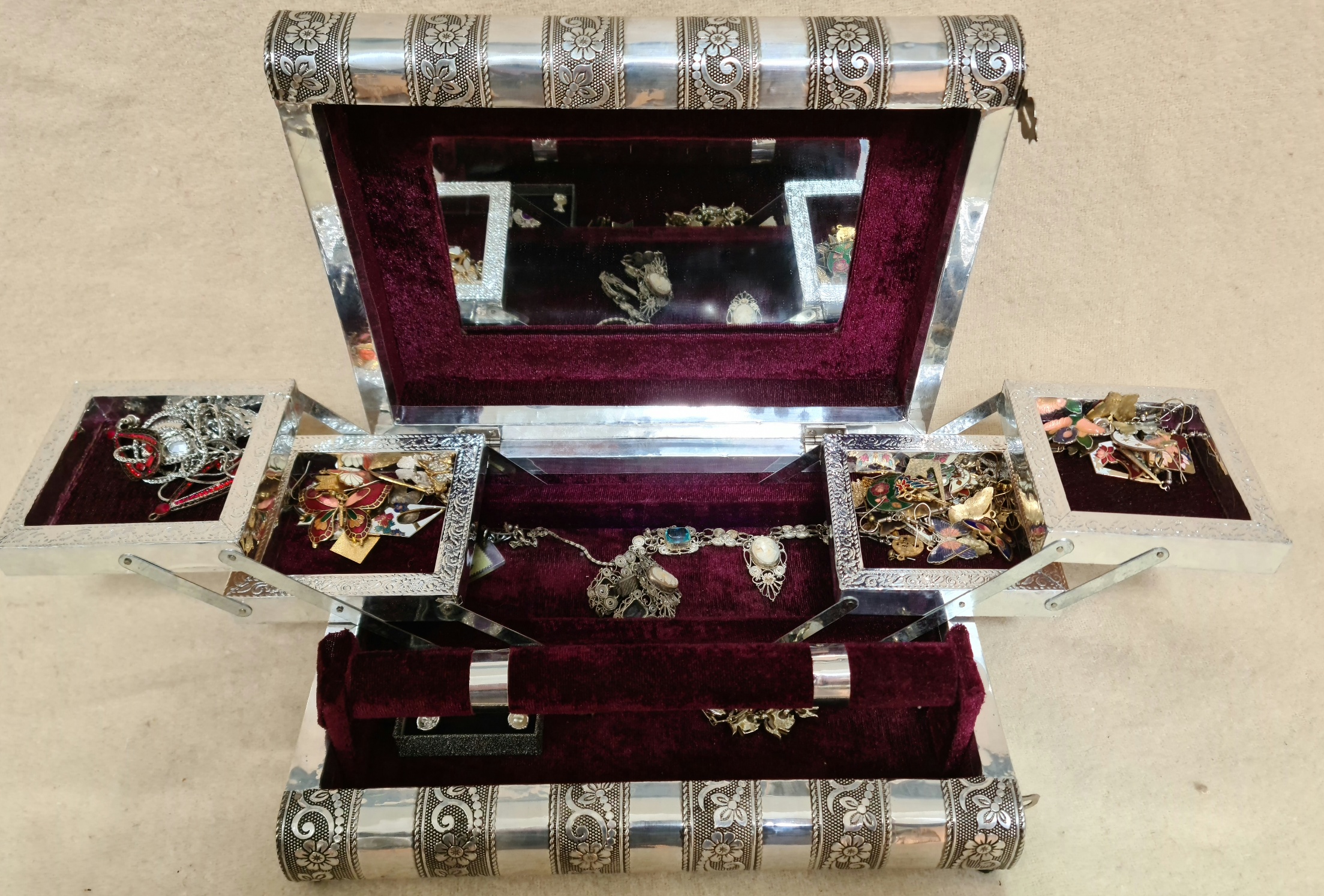 A white metal Indian style jewellery box in shape of 2 books, with cantilevered trays, rings support