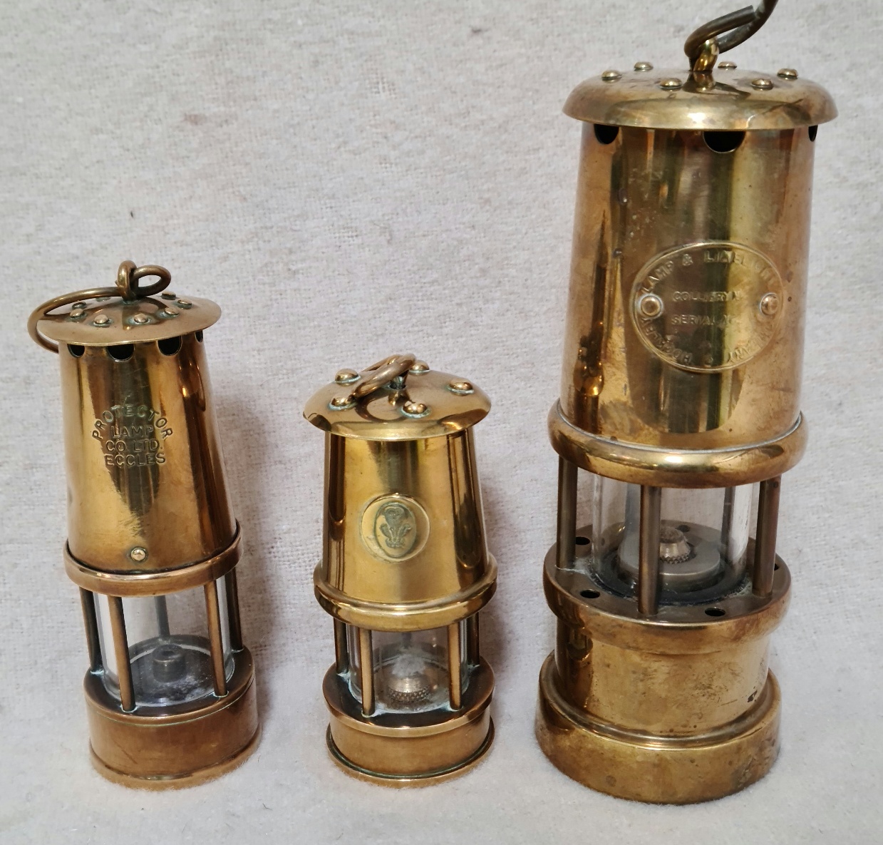 An unusual set of 3 graduated brass miner's lamps.