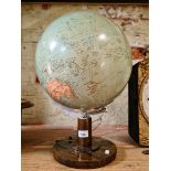 A glass spherical light globe with chrome support, on wooden base.