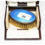 A cased set of 2 silver items comprising of a brush with blue enamel top and a comb, hallmarked