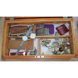 A wooden box containing watches, pens, pixies, etc.