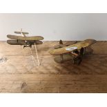 A pair of brass bi-planes, made of bullets & brass from a shell case, one large, one smaller,