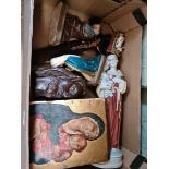 A box of assorted religious items including a polychrome wooden panel, carvings, etc.