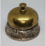 A white metal mounted brass desk bell, unmarked, diameter 8cm. Condition - various worn through