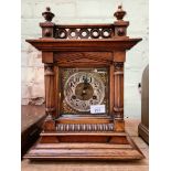 A wooden cased mantel clock with brass face, key and pendulum.