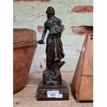 A bronze effect metal figure of a lady on stepped marble base.