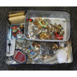 A tin of assorted costume jewellery.