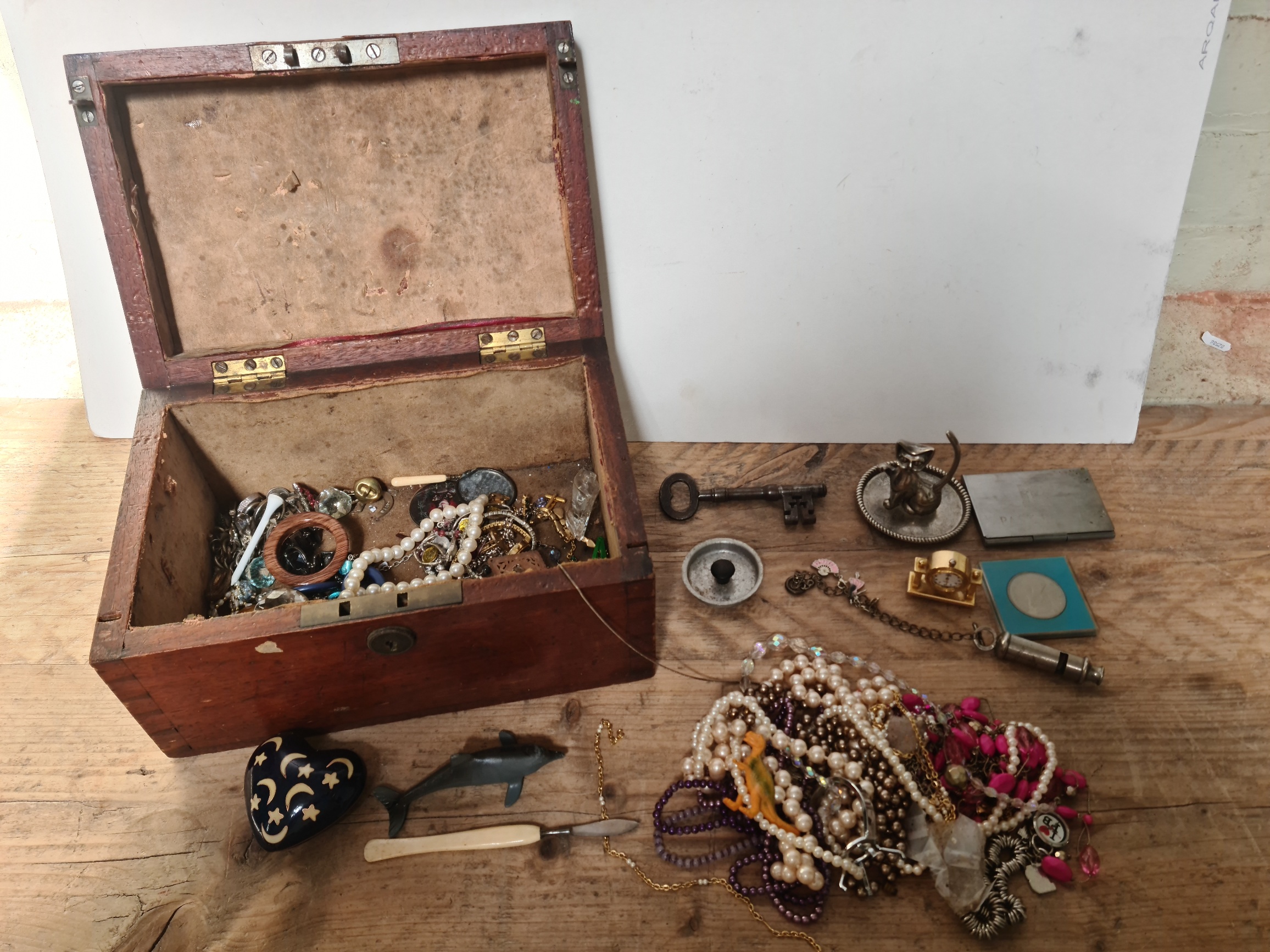 An old wooden box containing costume jewellery and collectables to include "The Metropolitan"
