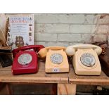 A group of three vintage telephones.