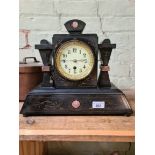 A Victorian black slate mantel clock with enamelled face, gilt rim and pendulum.