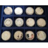 A collection of twelve Silver Proof Commemorative crowns in capsules and in a presentation box.