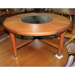 A mid 20th century G-Plan teak and smoked glass coffee table, diameter 96.5cm.