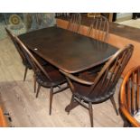 An Ercol dark beech and elm refectory dining table with six Ercol 'Quaker' dining chairs including