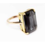 A synthetic colour change sapphire ring, the central emerald cut stone weighing approx. 13.13ct,