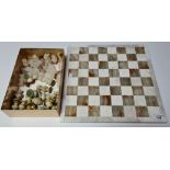 A marble and onyx chess board and onyx and marble chess pieces.