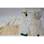 A group of three antique christening gowns, together with a table cloth etc.
