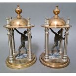 A pair of Classical style figures under brass dome with chromed columns.