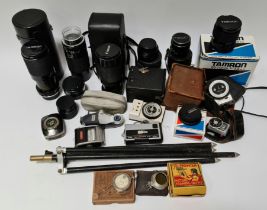 A box of camera equipment including lenses, tripod, vintage light meters etc.