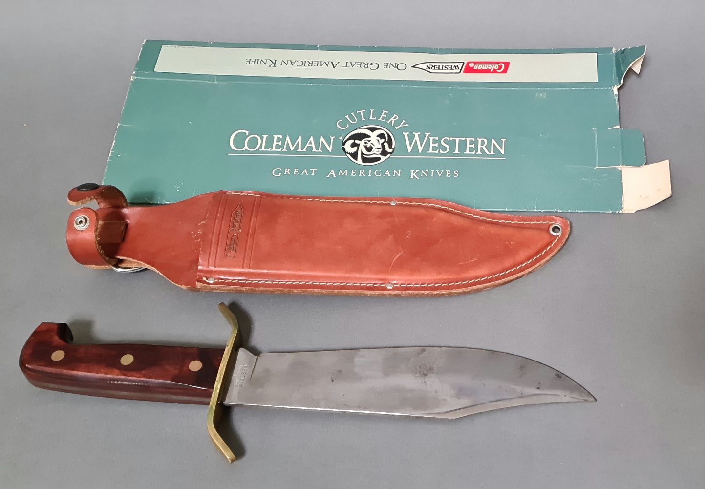 An American Coleman Western Bowie knife with leather scabbard and outer box, circa 1980s.
