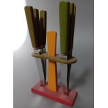 An Art Deco red, orange and green bakelite knife set, the curved steel blades marked 'Rostfrei'.