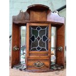 An Edwardian Arts & Crafts style oak corner smoker's cabinet.