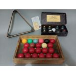 A set of vintage snooker balls and a triangle, together with a cased set of carpet bowls.