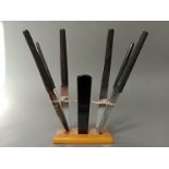 An Art Deco style black and butterscotch knife stand with butterfly holders, the serrated steel