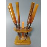 An Art Deco knife marble bakelite knife stand with six knives, the steel blades marked 'Rostfrei'.