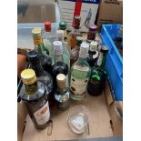 A box of part used bottles of alcohol including
