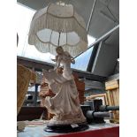 A decorative table lamp in the form of a lady.