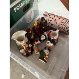 A box of assorted ornaments including Toby jugs, carved magazine rack etc.
