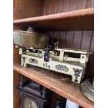 A vintage cast metal 5kg balance scale with brass tray and weights.