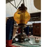 A metal and amber glass ornate table lamp.