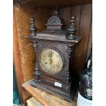 A carved wooden mantle clock with pendulum and key