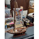 A wooden model yacht on a plinth