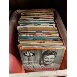 A box of 1960s 7" vinyl records.