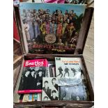 A vintage leather case containing Beatles records, books and memorabilia.