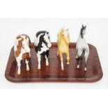 A group of four Beswick ponnies, length approx. 18cm each.