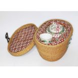 A Chinese porcelain tea pot and tea bowls with basket.