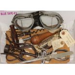 A box of assorted collectables comprising mainly corkscrews and a pair of motorcycle goggles.