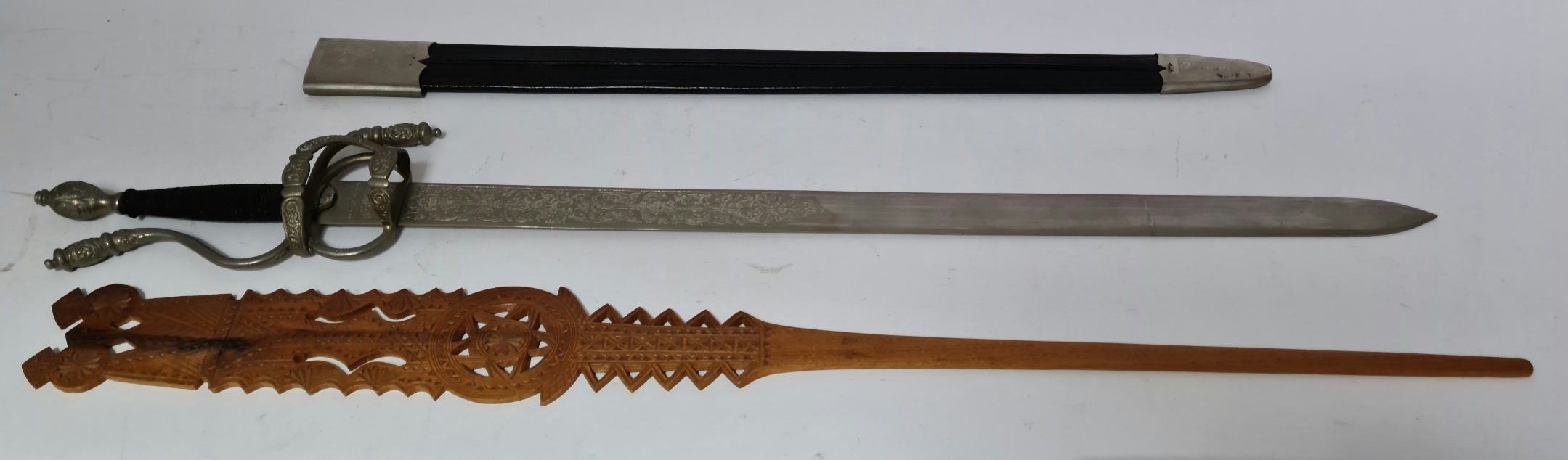 A reproduction Toledo steel sword and a carved wooden wool comb.