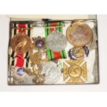 A tin of assorted medals and badges.