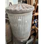 A galvanised dust bin with lid.