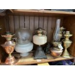 A group of 6 oil / paraphin lamps to include an Arts and Crafts copper lamp - no funnel and no
