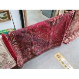 A vintage eastern hand knotted wool carpet, red ground, 250cm x 170cm.