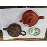 Two Japanese teapots and a small Eastern dish.
