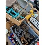 A box of assorted metalware including brass items, weights, trivets and a miniature sewing machine.