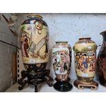 Three repro Eastern vases on stands.
