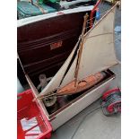 A tin trunk and contents including a vintage 1954 Triang pedal scooter, a model sail boat and a