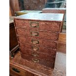 A set of filing drawers containing various pens, ink and a collection of matchboxes.